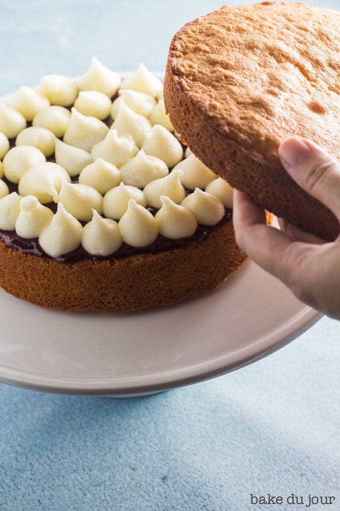 Placing the second sponge on top to make the Victoria Sandwich Cake